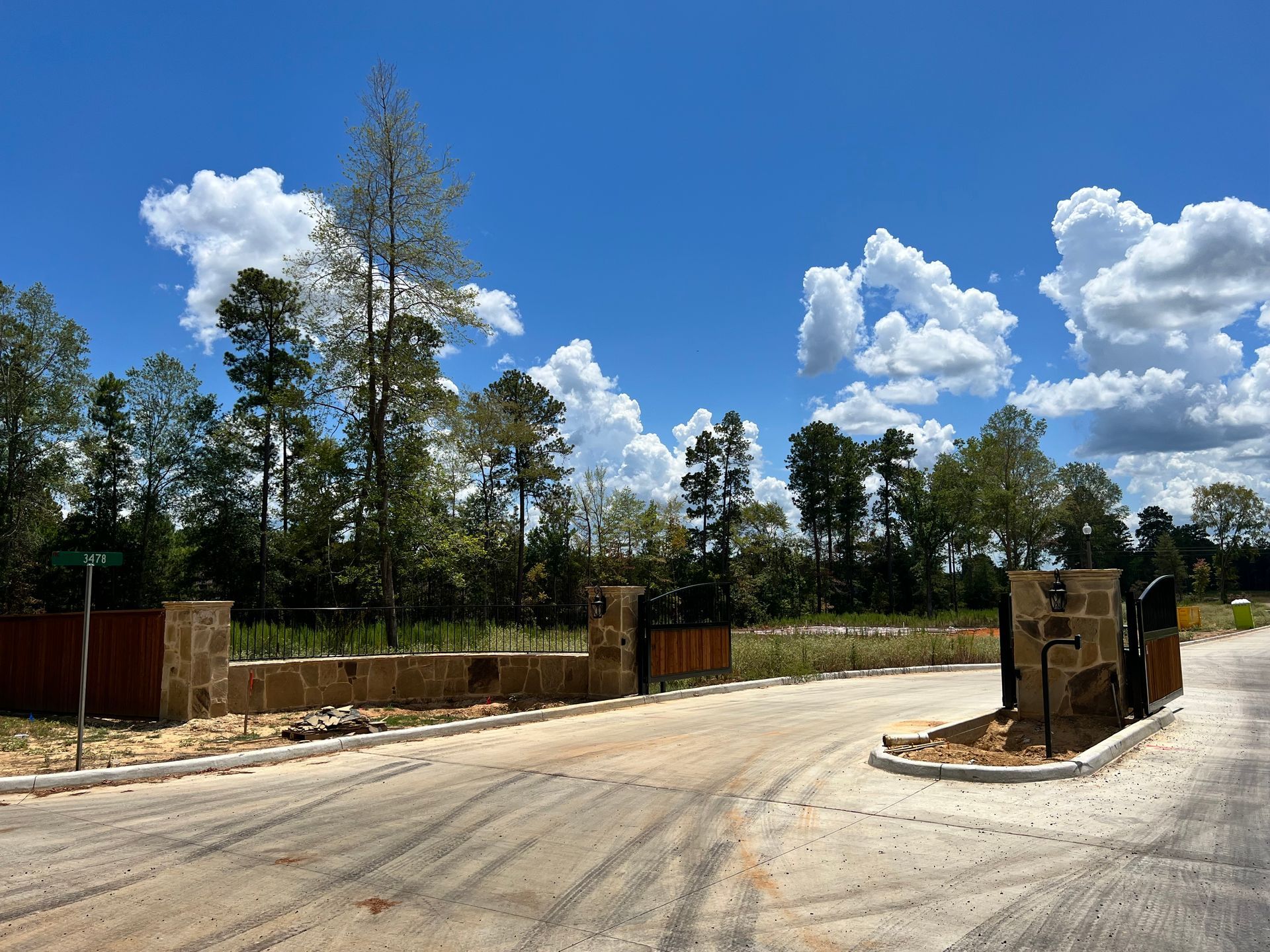 A gated entrance to a residential area with trees in the background
