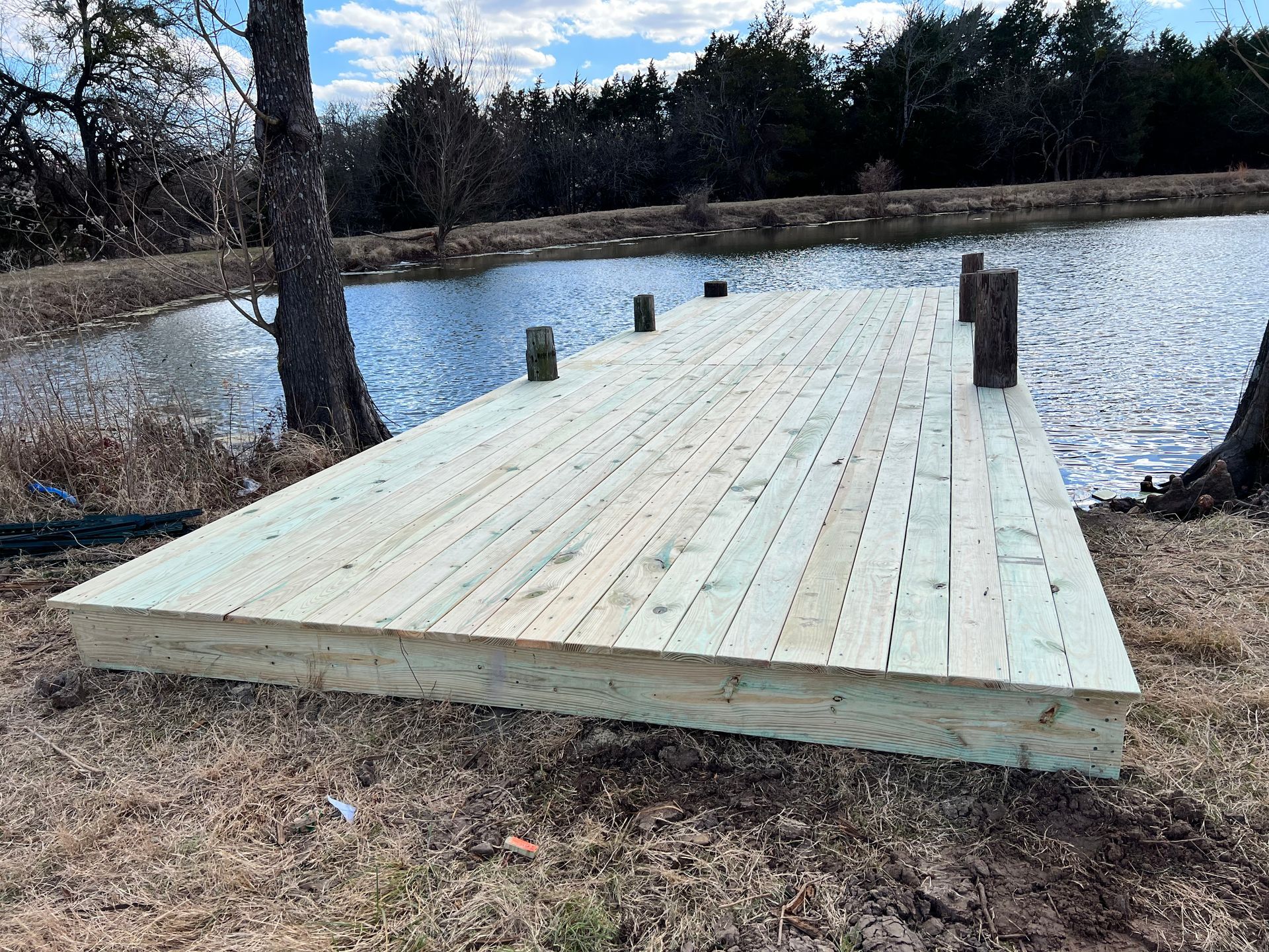 A wooden dock is sitting next to a lake.