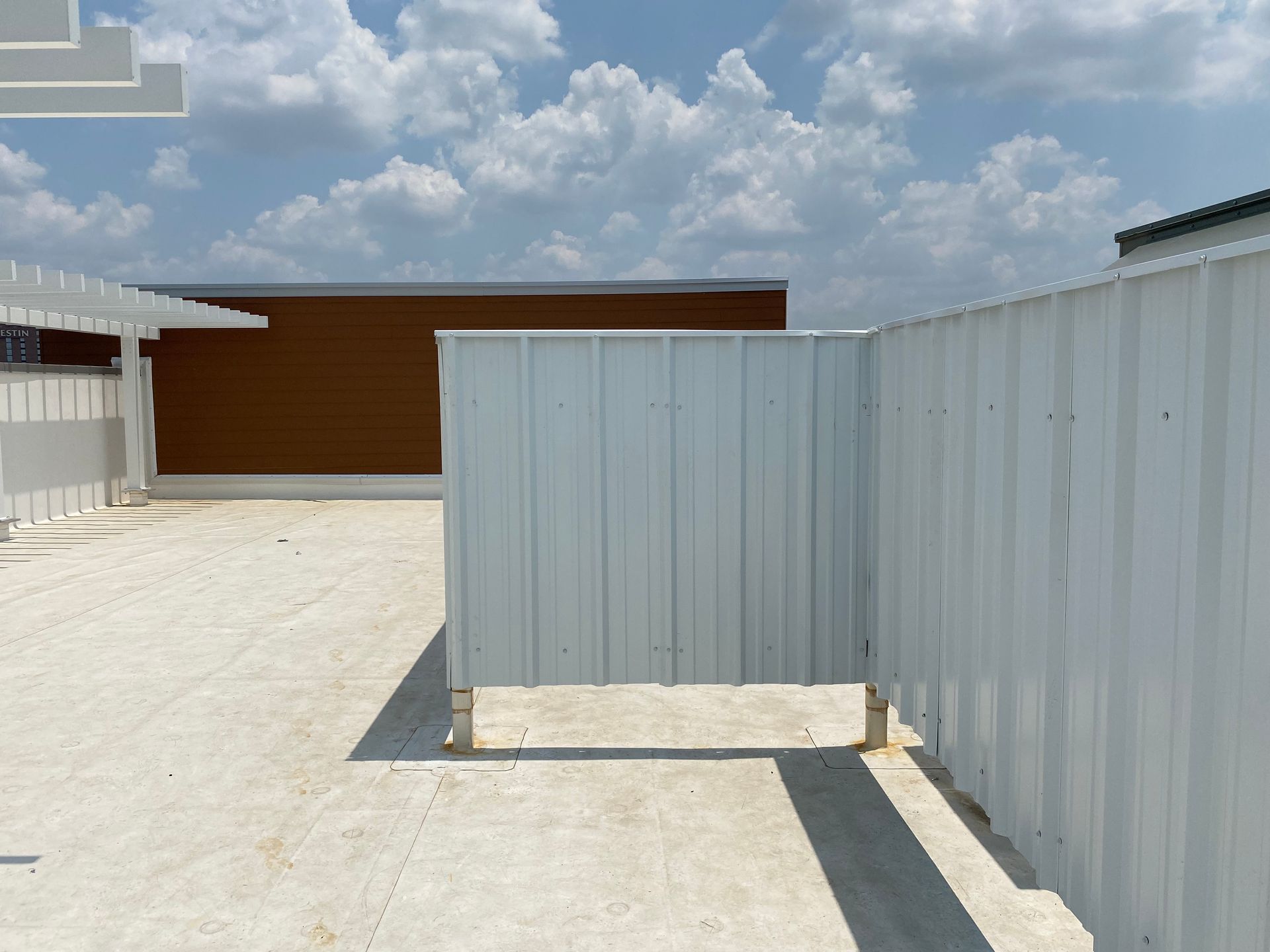 A white fence with a brown building in the background