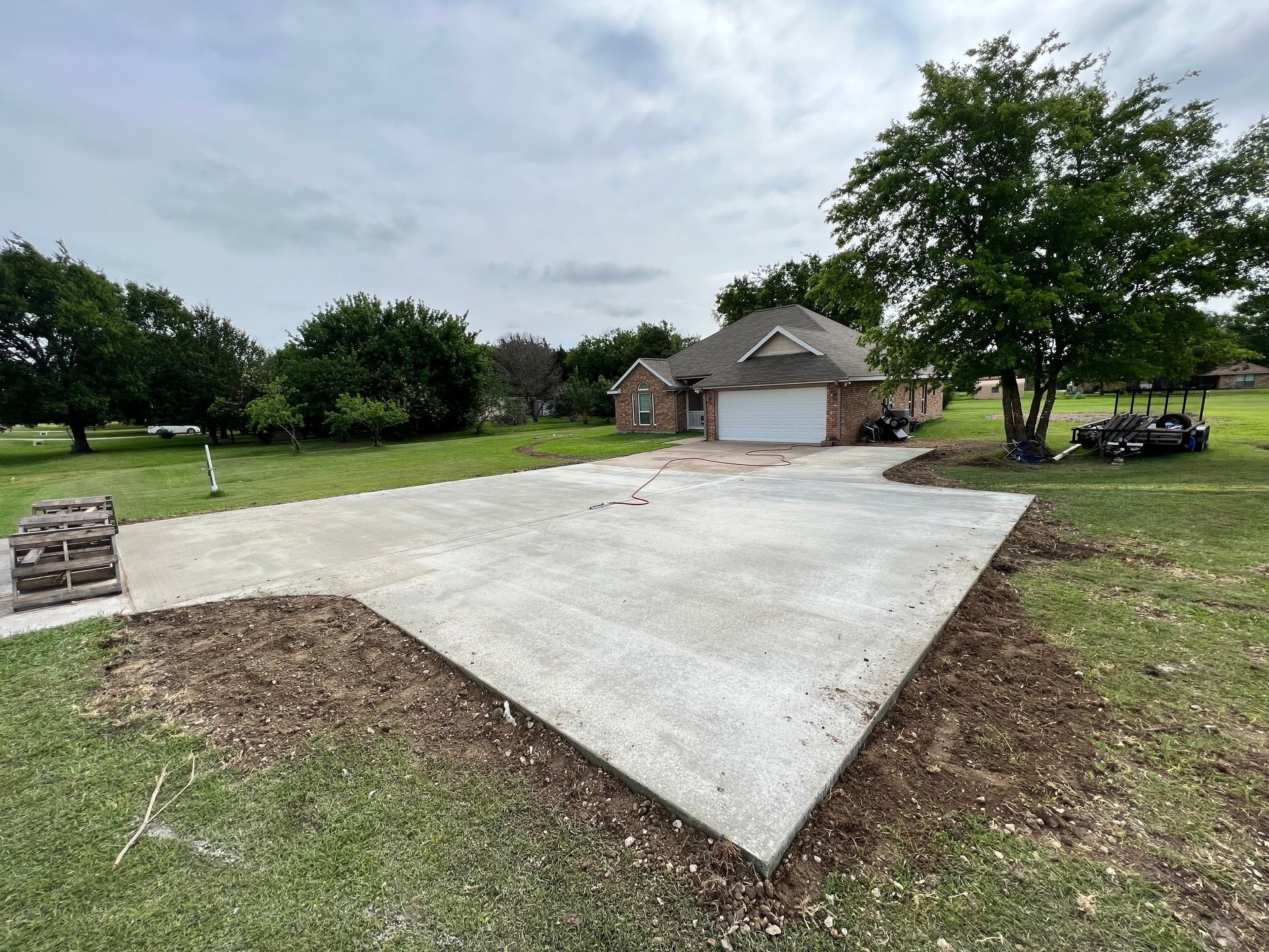 A concrete driveway is being built in front of a house.