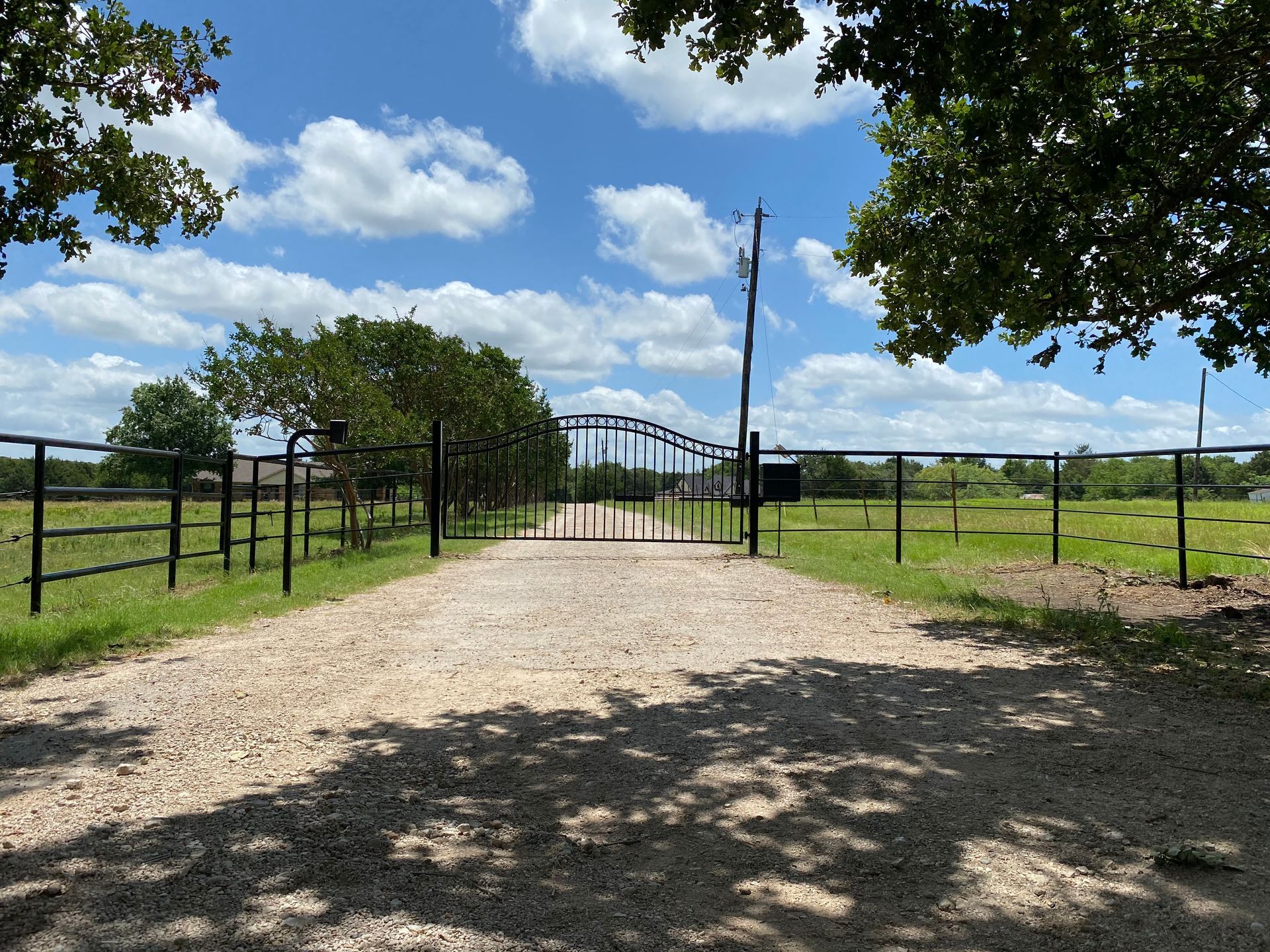 A dirt road with a gate in the middle of it