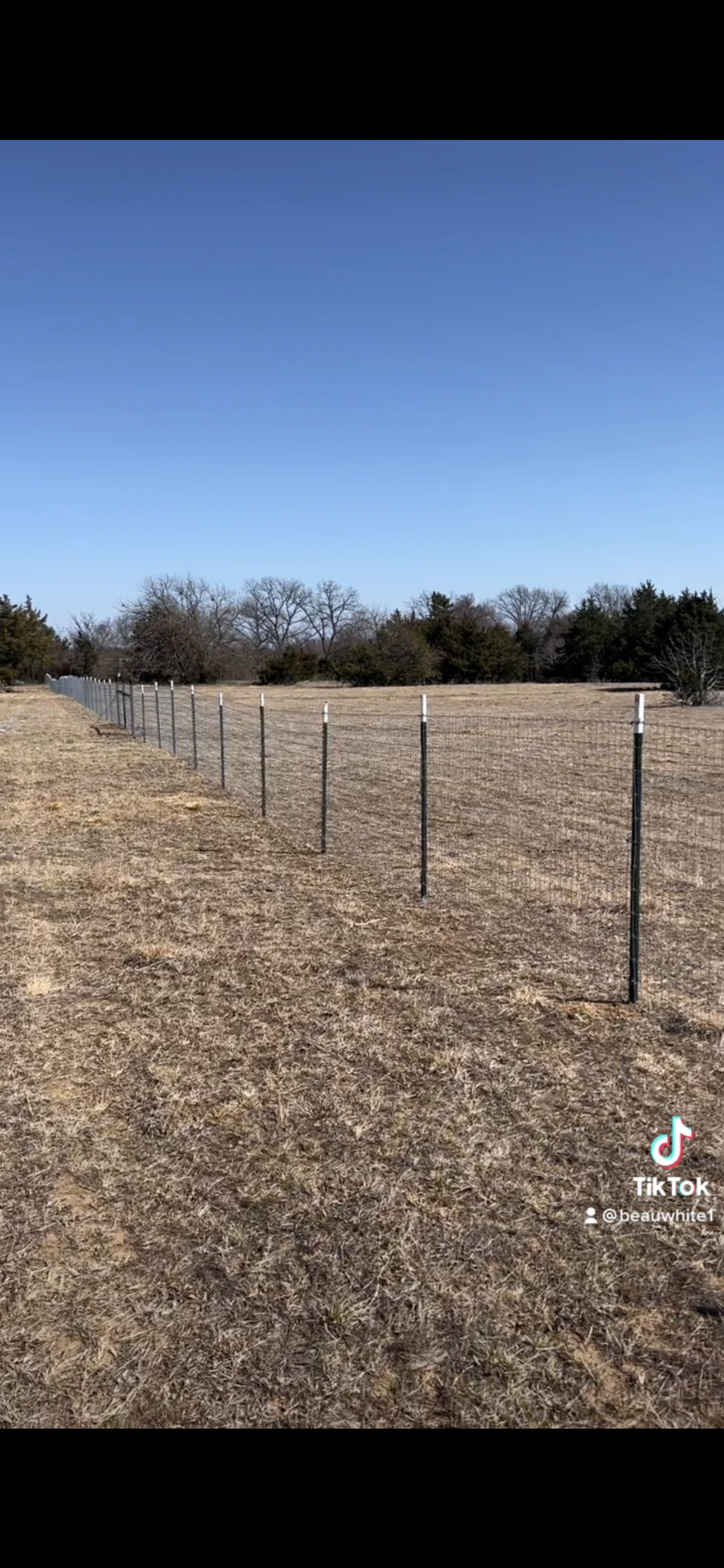 There is a fence in the middle of a field.
