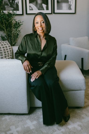 A woman is sitting on a couch in a living room.