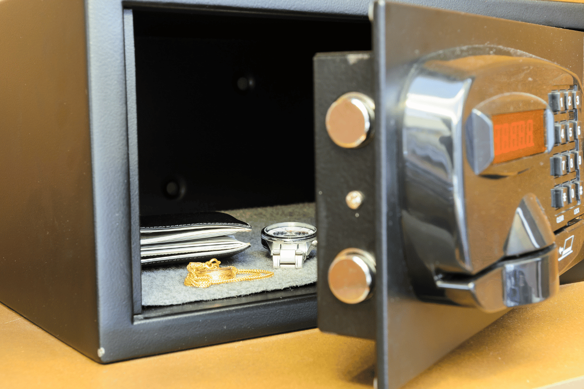 Safe open with wallet, watch, and gold chain inside.