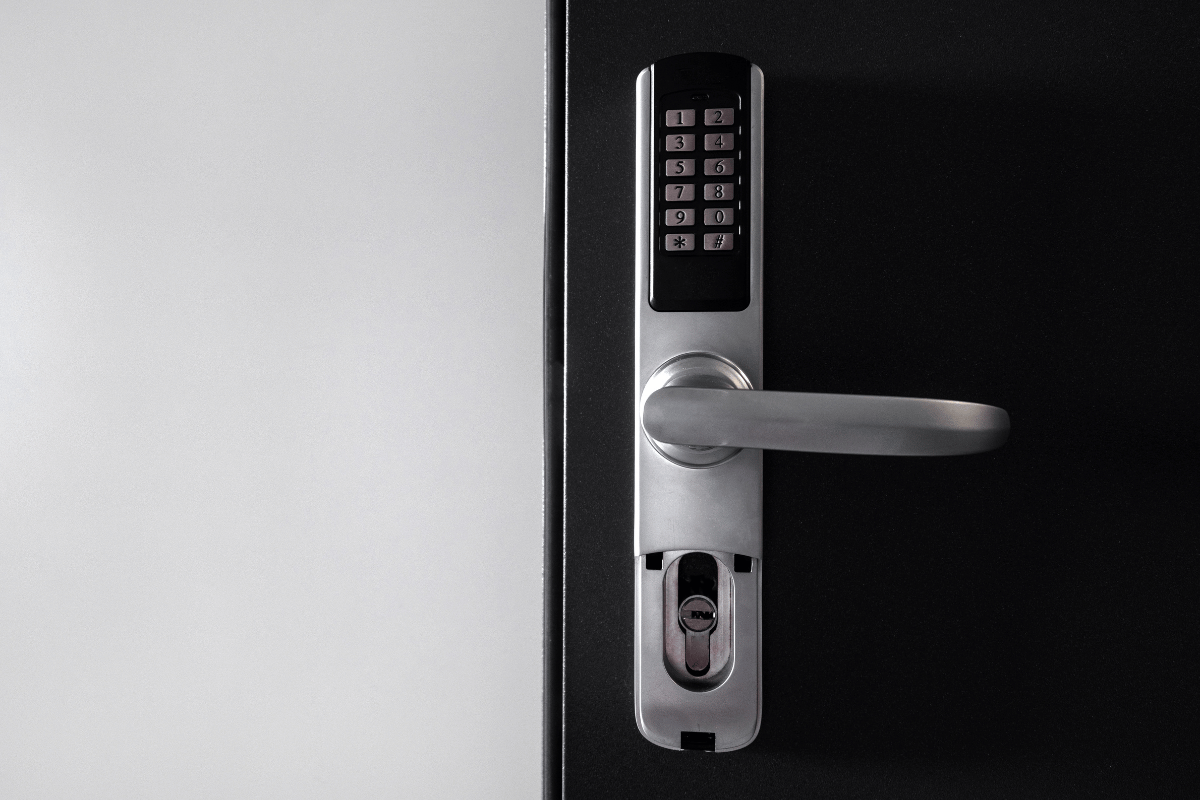 Digital door lock with keypad and handle on a black door.