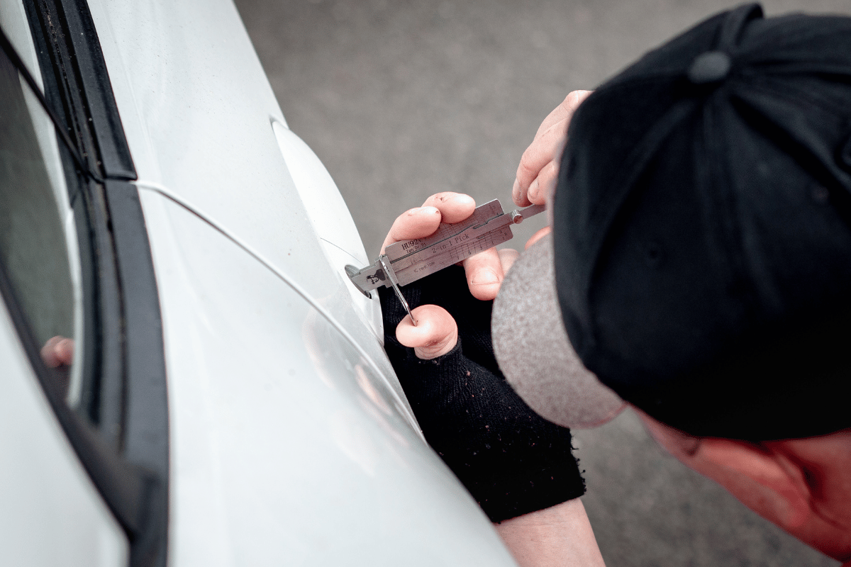 Person using lock picks to open a car door.