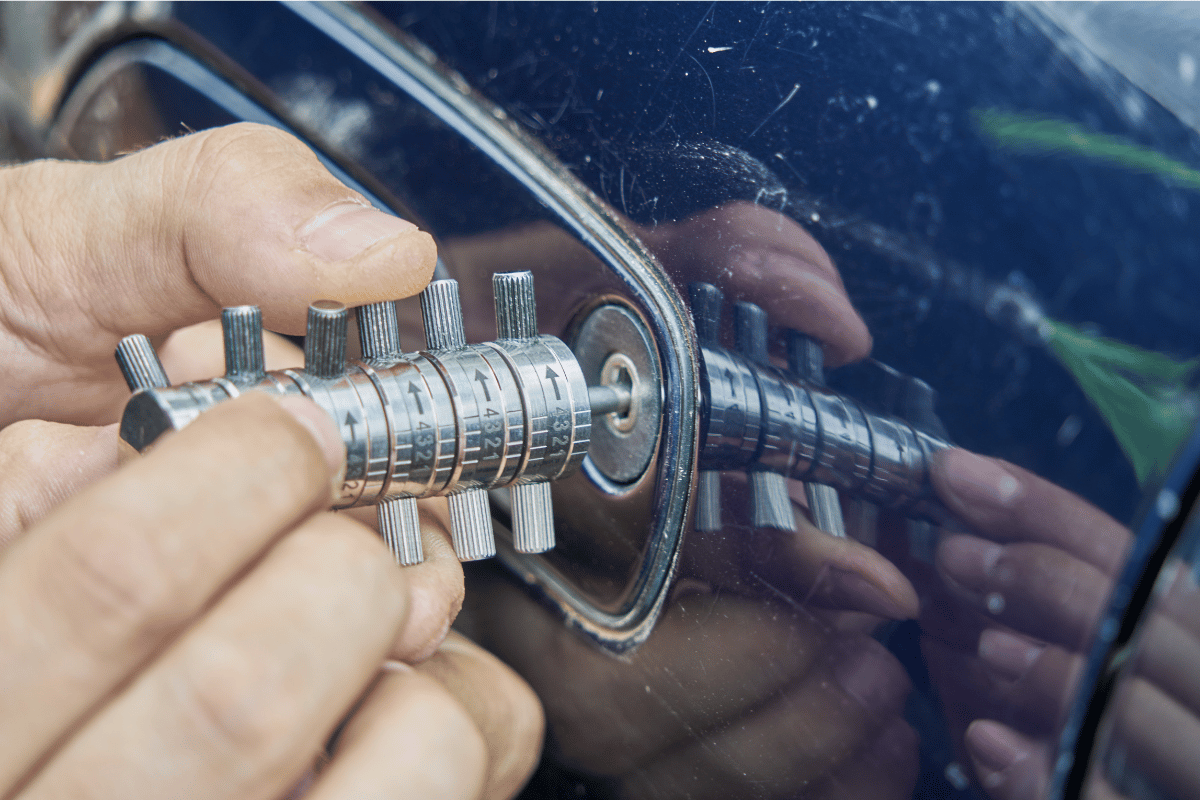 Person using a lock pick to open a car door lock.