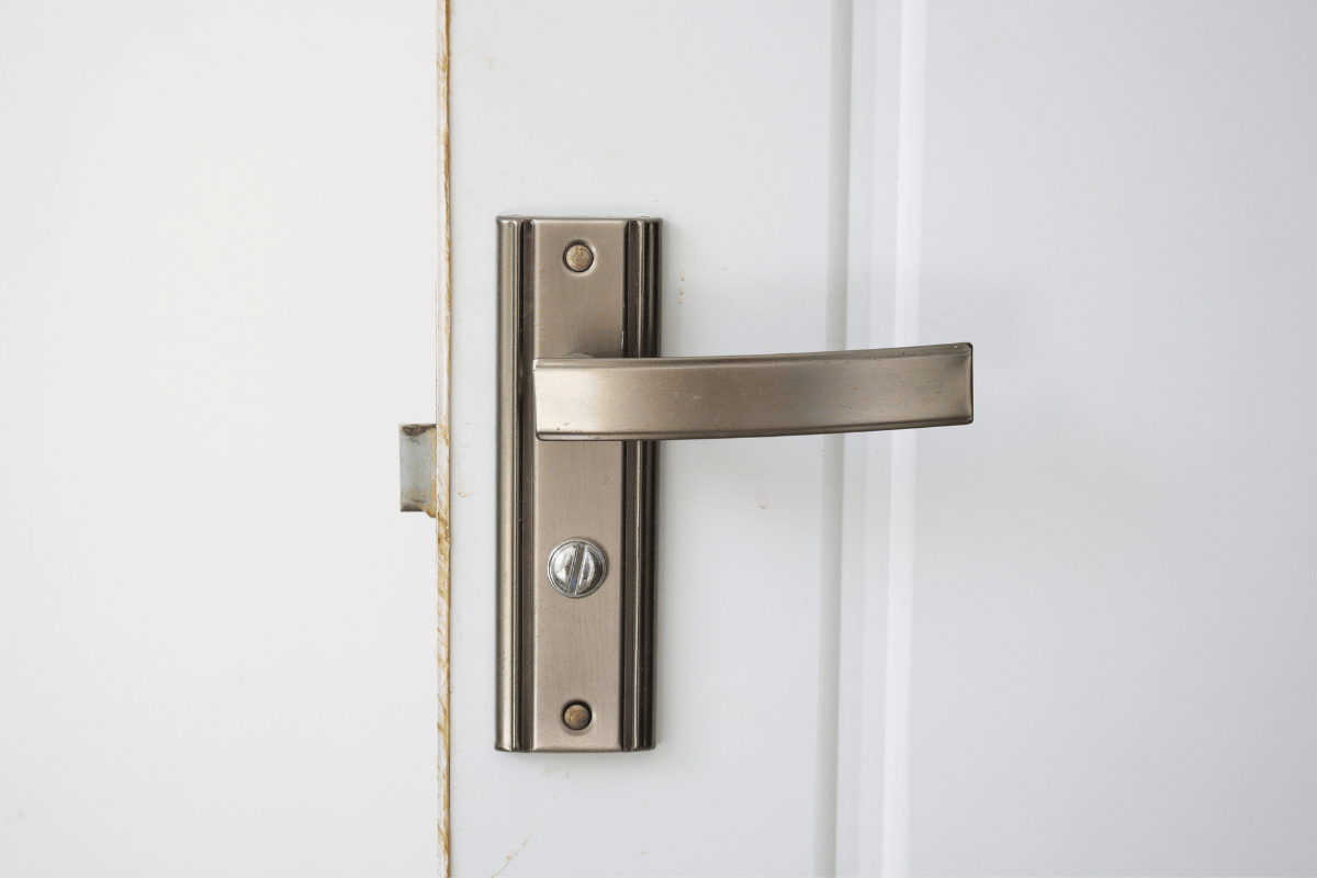 Silver door handle on a white door.