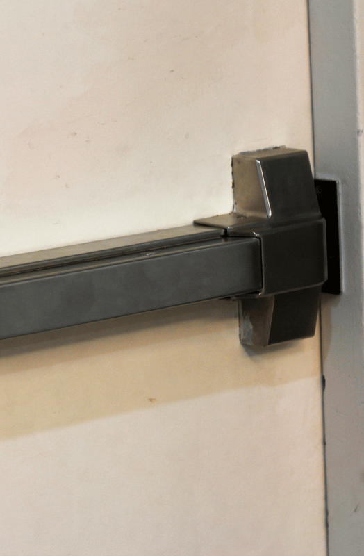 Silver crash bar on a white door.