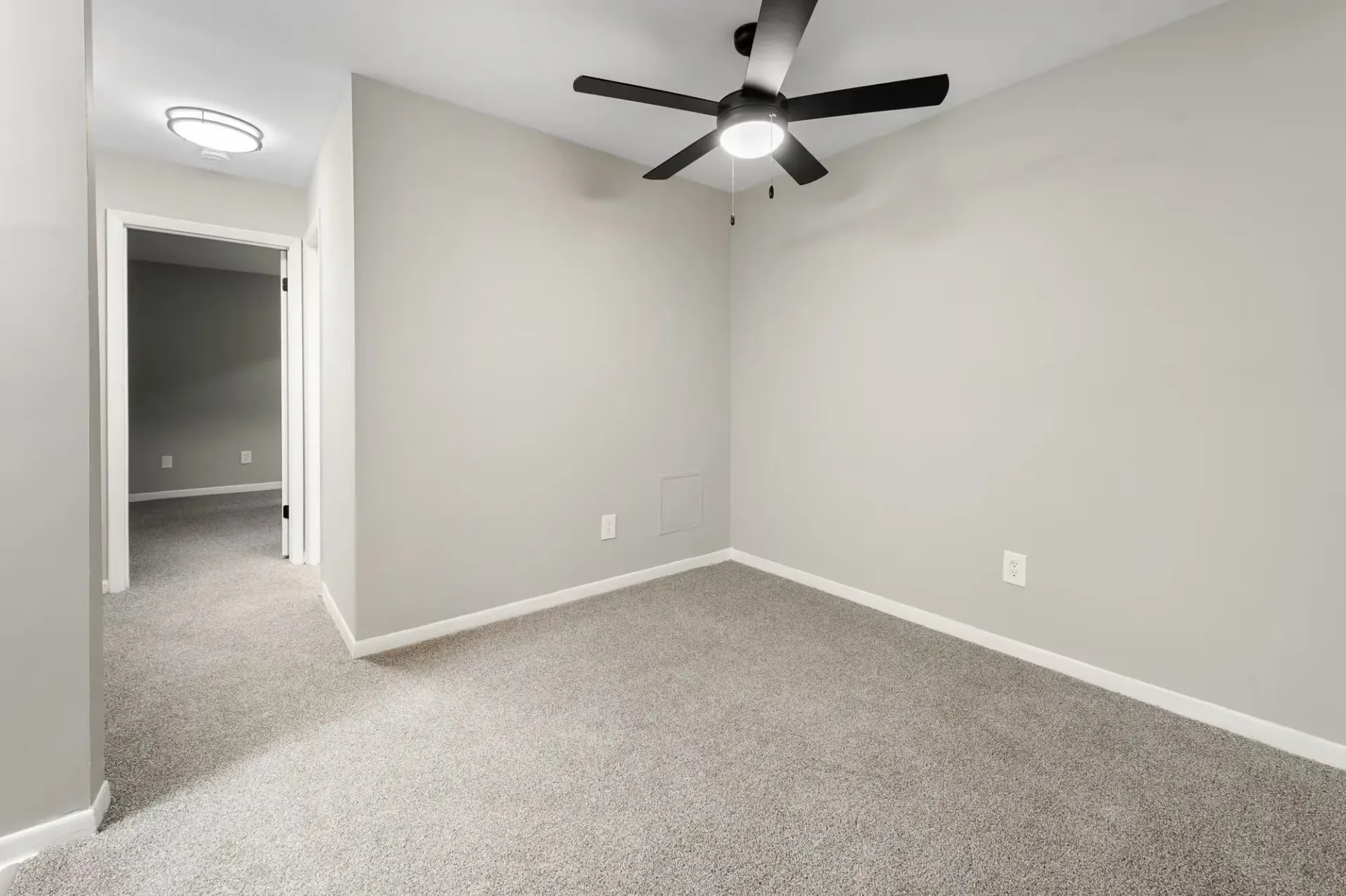 Empty bedroom with neutral gray walls, beige carpet, and a ceiling fan at The Ridge Apartments in Hagerstown, MD