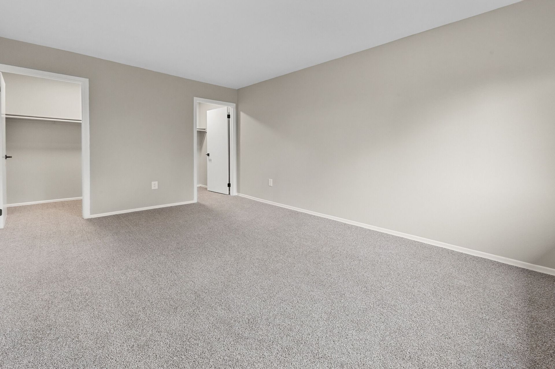Empty bedroom with neutral walls, carpet, and open closet doors at The Ridge Apartments in Hagerstown, MD