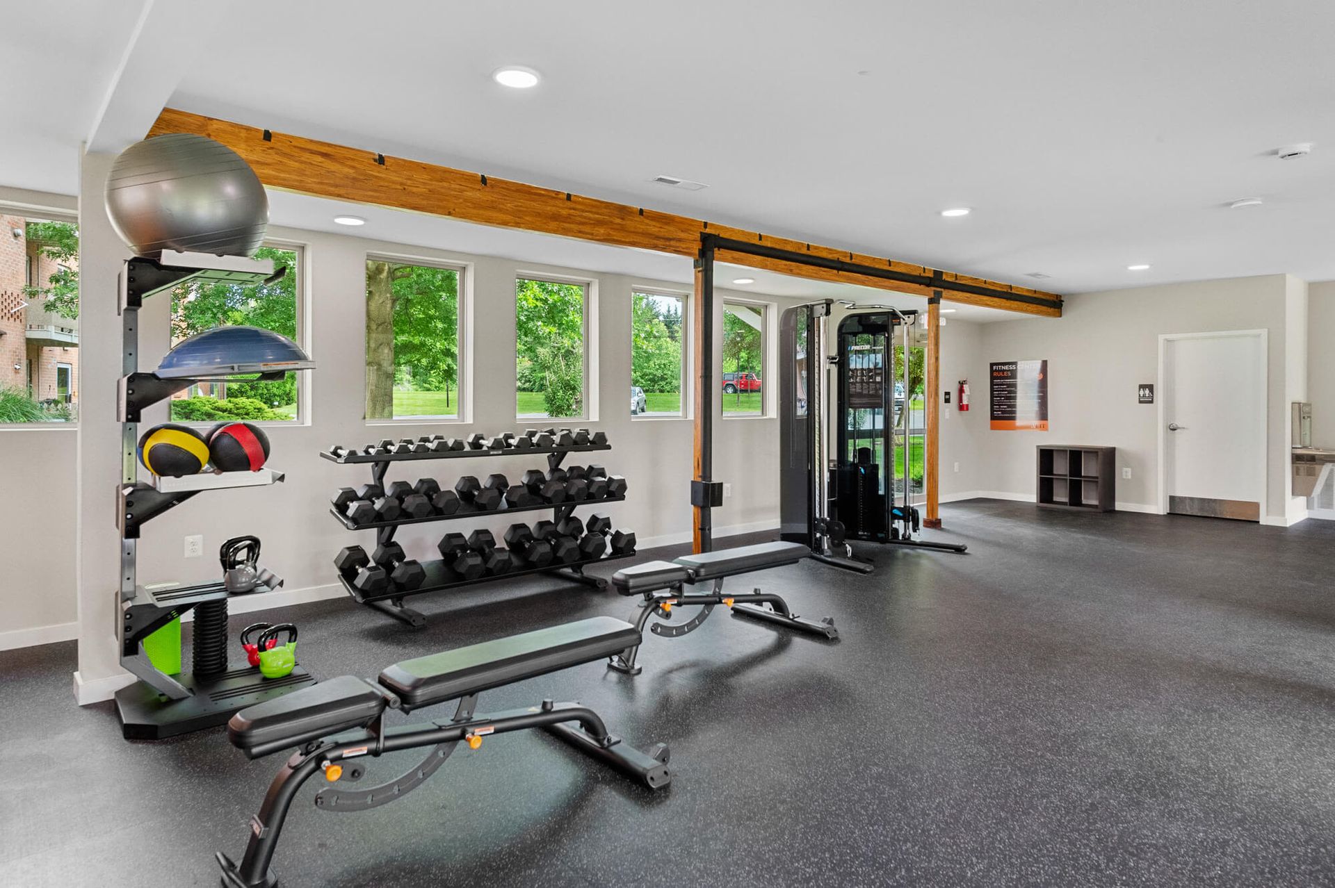 Bright community gym with free weights, benches, medicine balls, and a cable machine at The Ridge Apartments in Hagerstown, MD