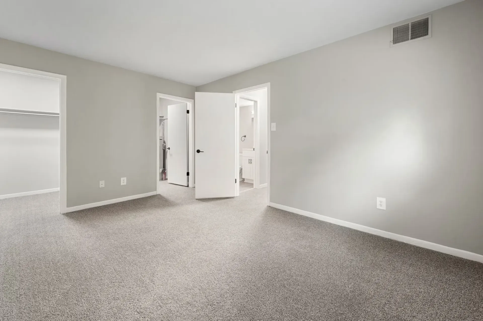 Interior bedroom in an apartment with gray walls, carpet, a closet, and doorway to adjoining spaces at The Ridge Apartments in Hagerstown, MD