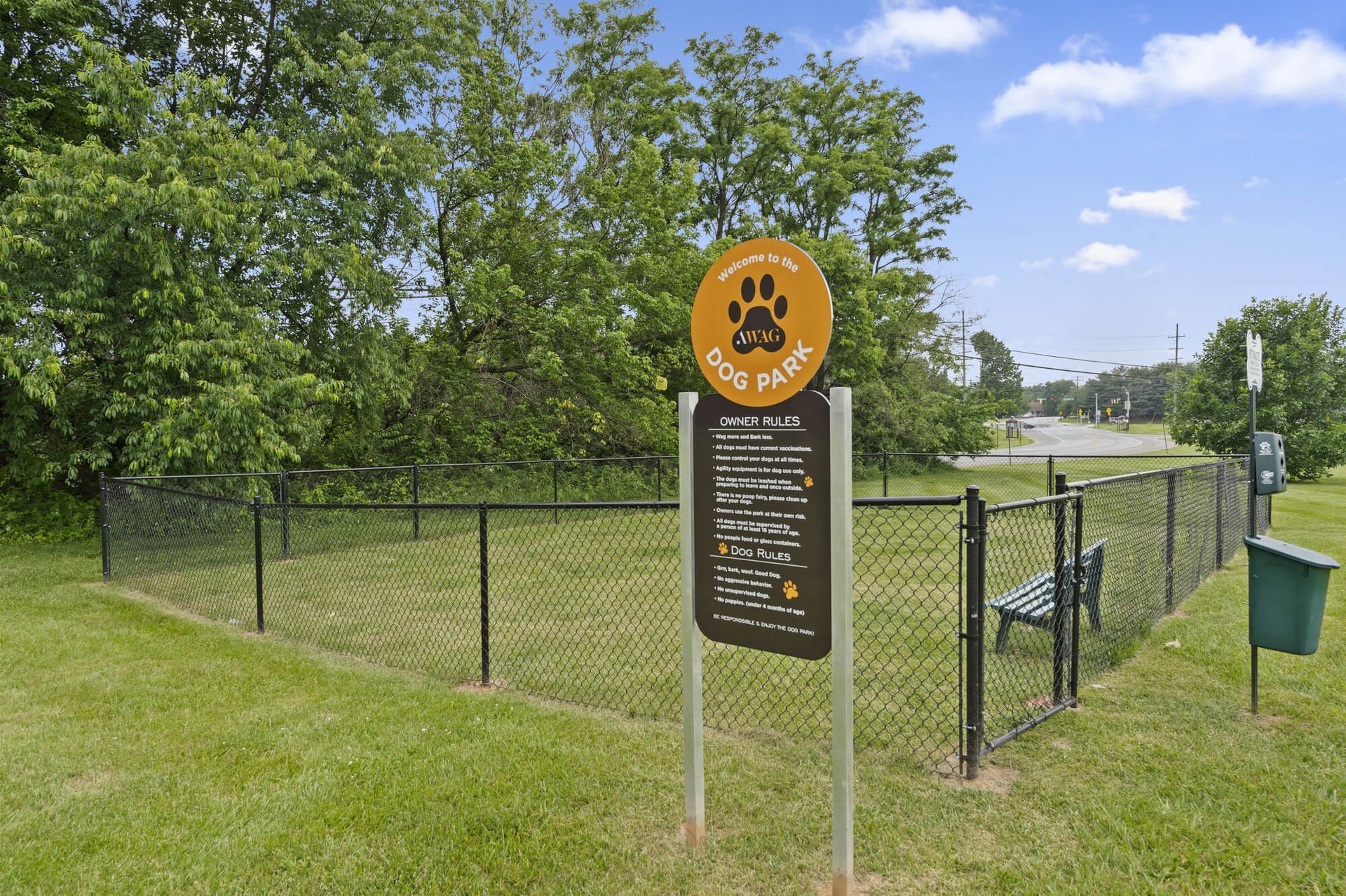 Dog park sign inside a fenced grassy area with trees at The Ridge Apartments in Hagerstown, MD