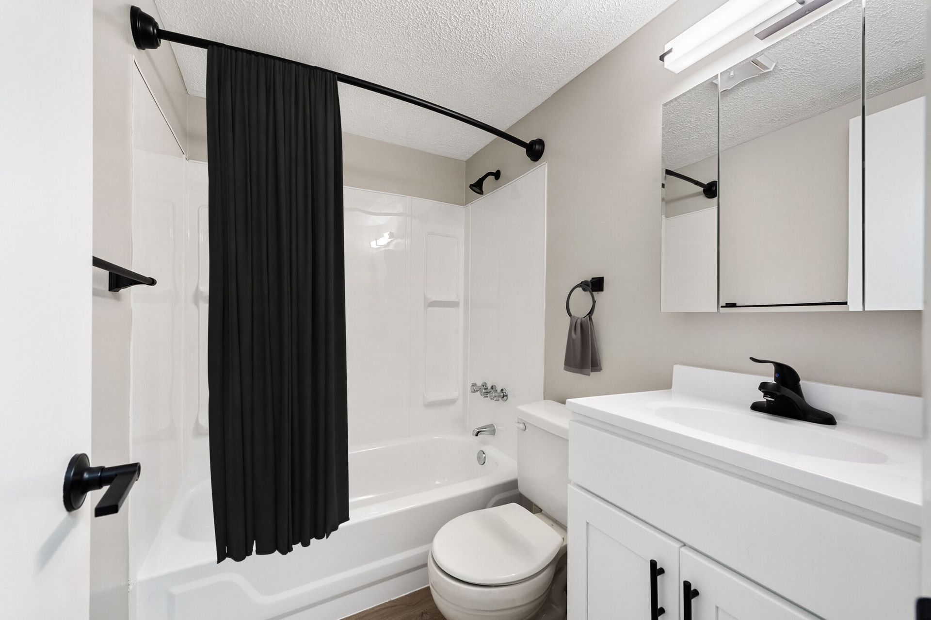 White bathroom with a tub/shower, toilet, and a white vanity at The Ridge Apartments in Hagerstown, MD