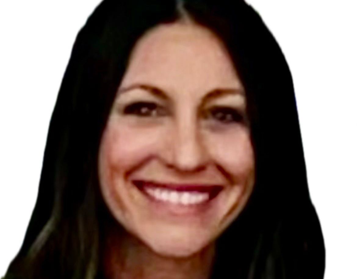 A woman with long dark hair is smiling for the camera