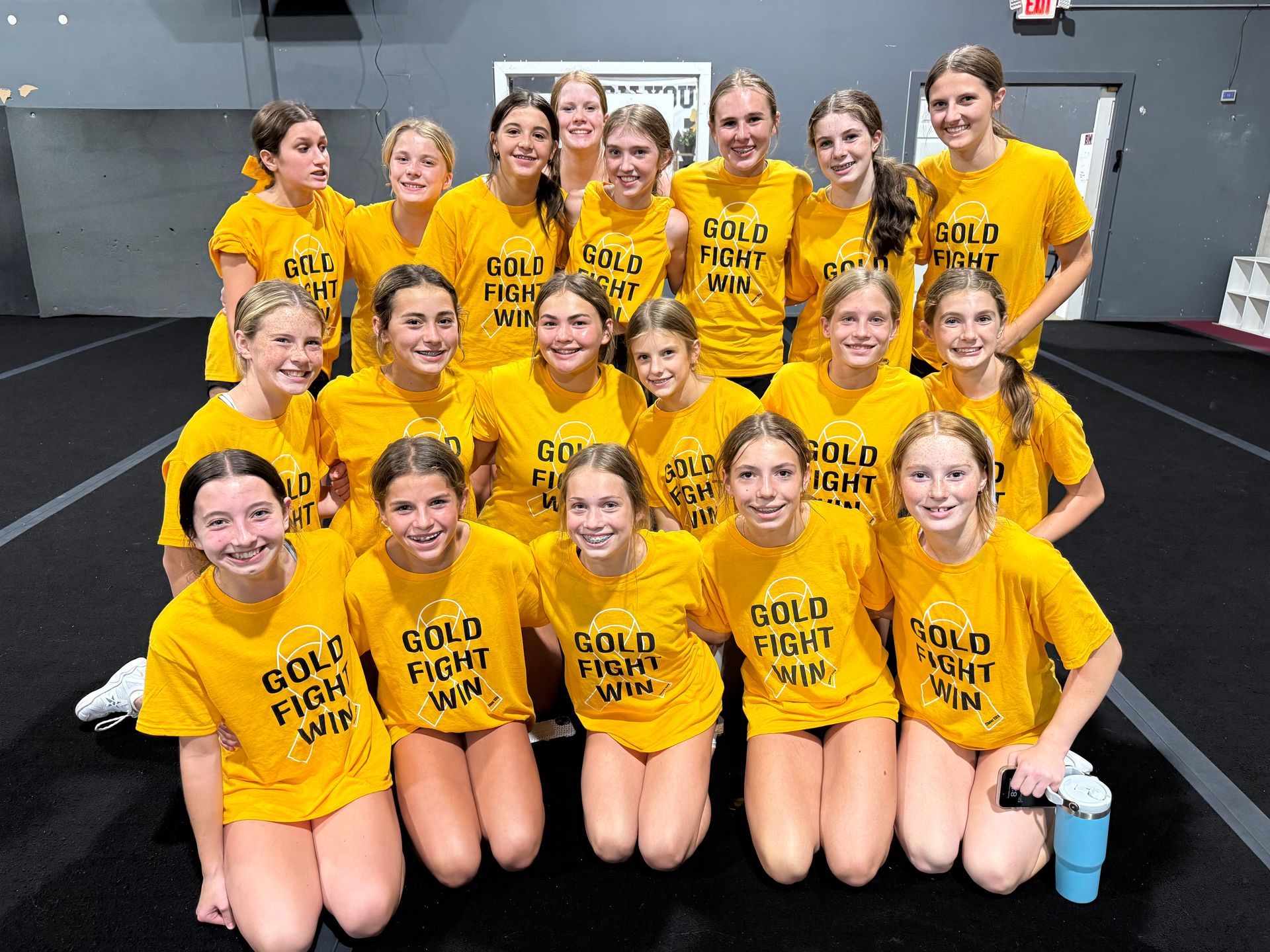 A group of cheerleaders are performing a routine in a gym.