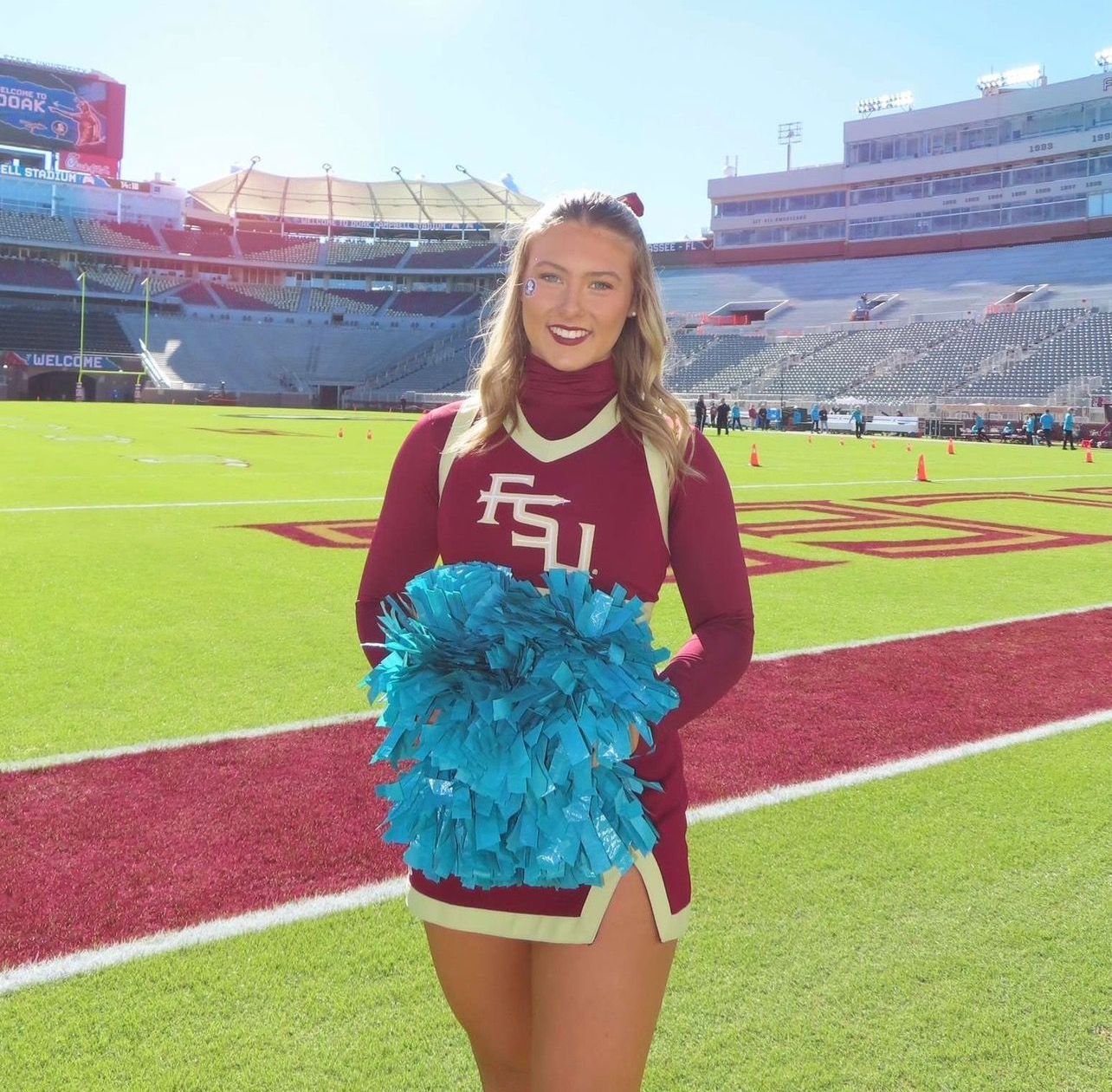 A woman is smiling in front of a building that says ge