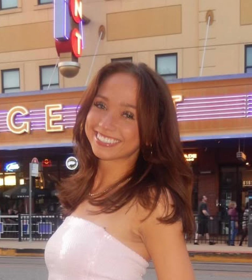 A cheerleader for the university of florida is holding blue pom poms