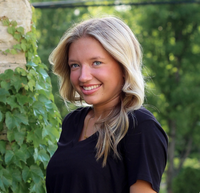 The woman is wearing a black shirt and smiling for the camera.