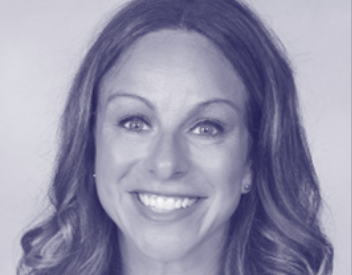 A woman with long hair is smiling in a black and white photo.