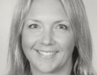 A woman is smiling in a black and white photo.