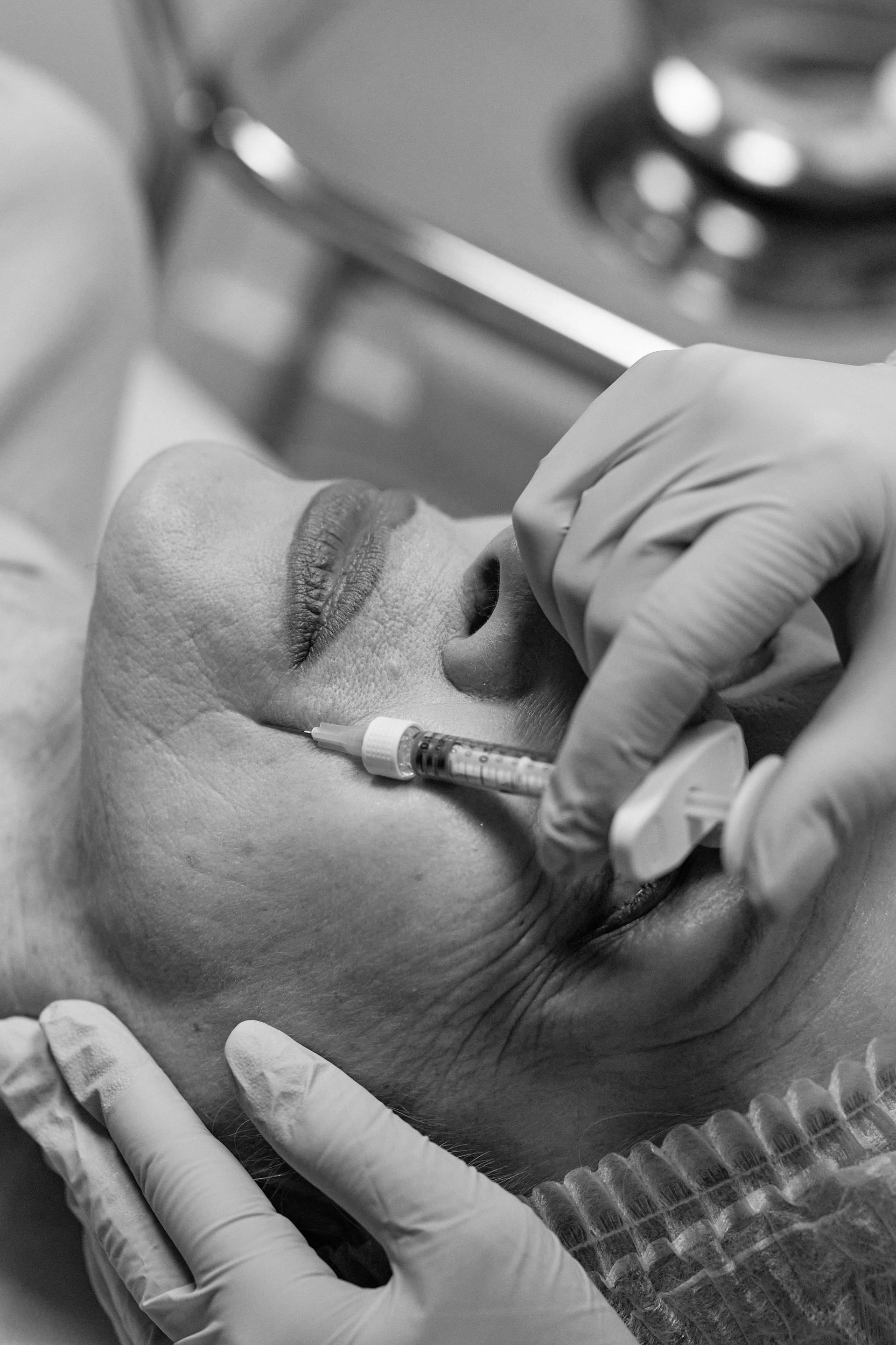 A woman is getting a botox injection in her face.