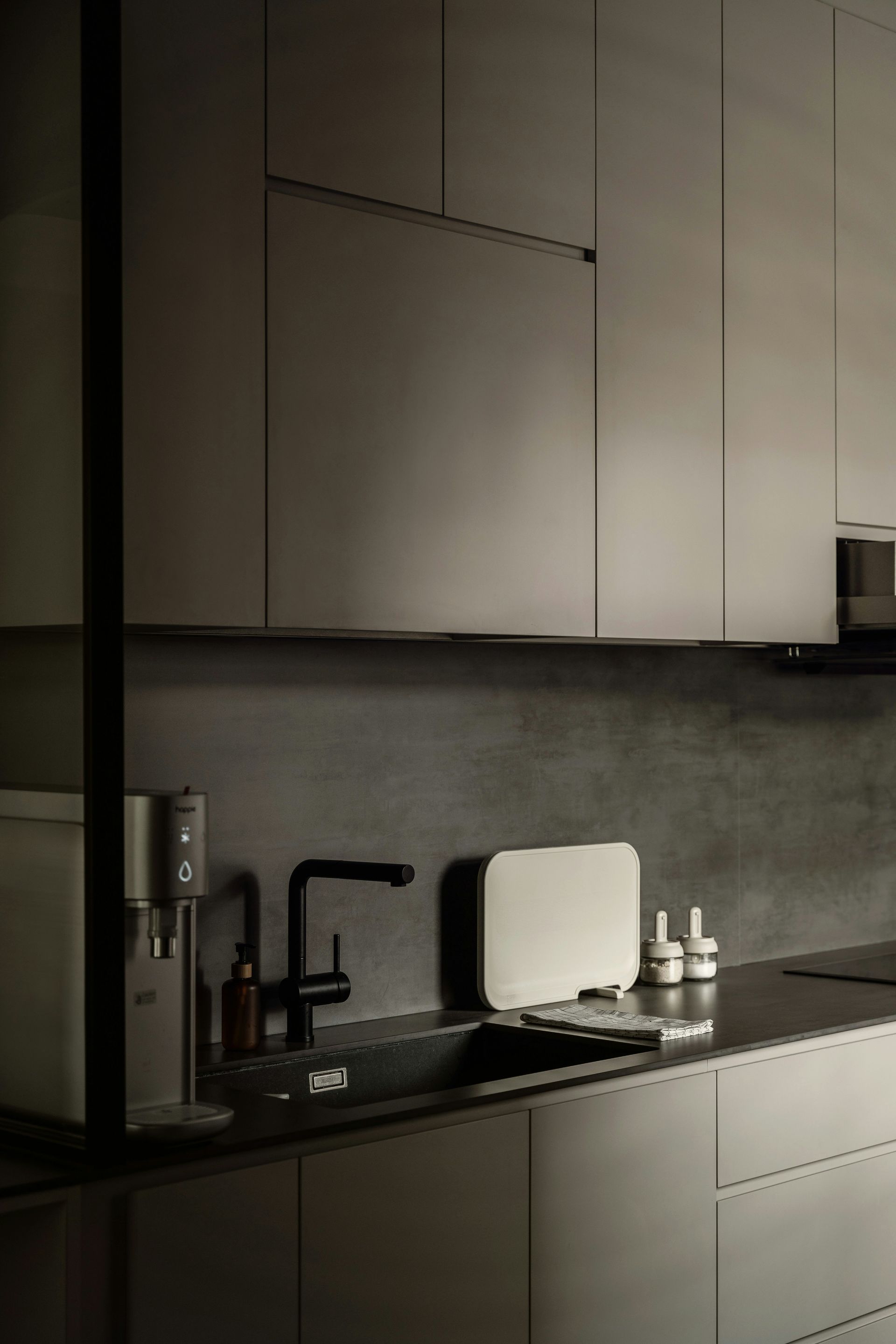 A kitchen with a sink , faucet , and cabinets.