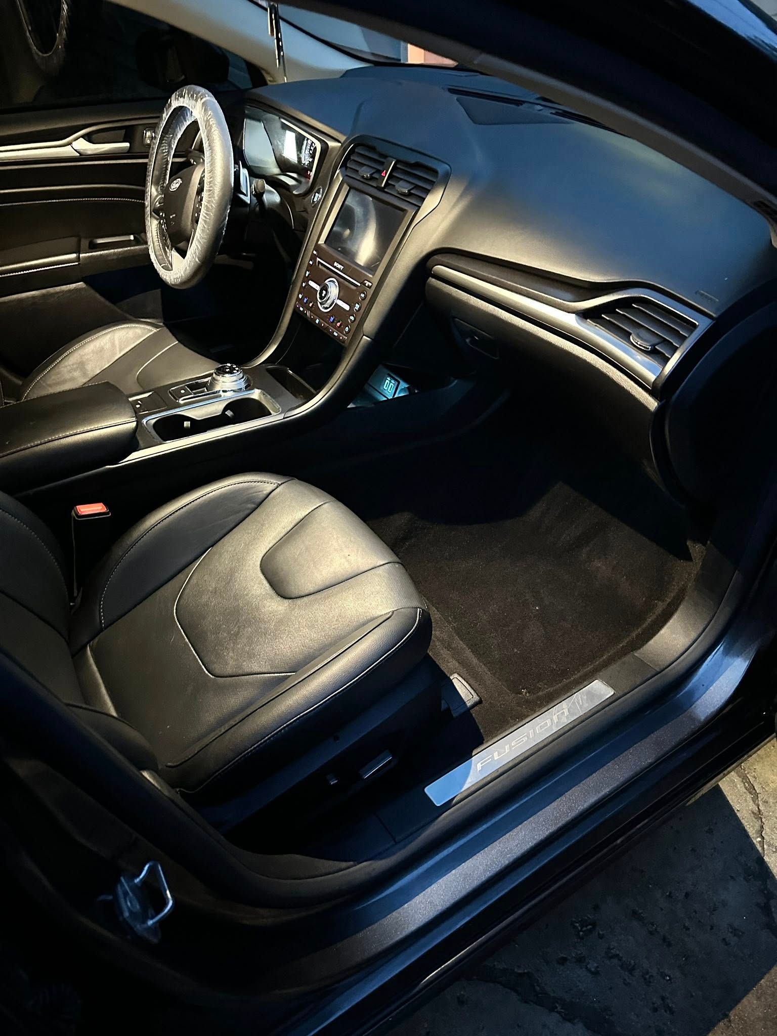 The interior of a black car with the door open