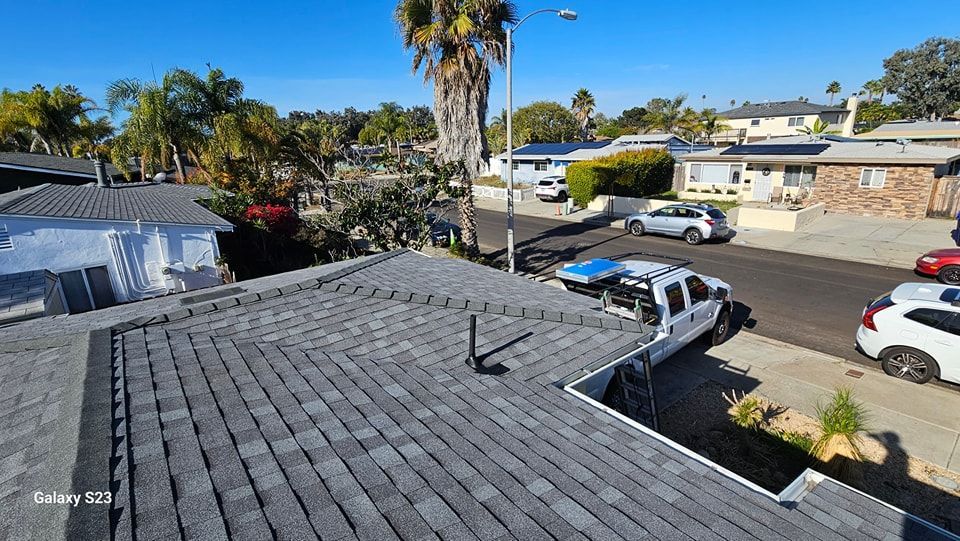 View of rooftops and street in a residential neighborhood on a sunny day.