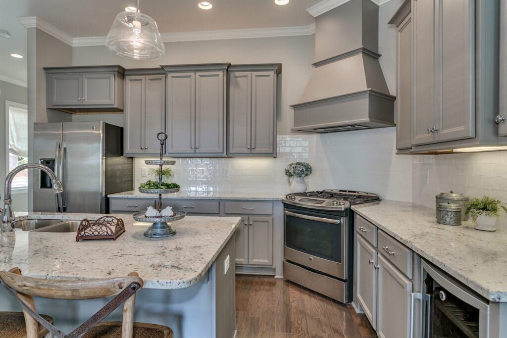 Gray kitchen with granite countertops, stainless steel appliances, and gray cabinets.