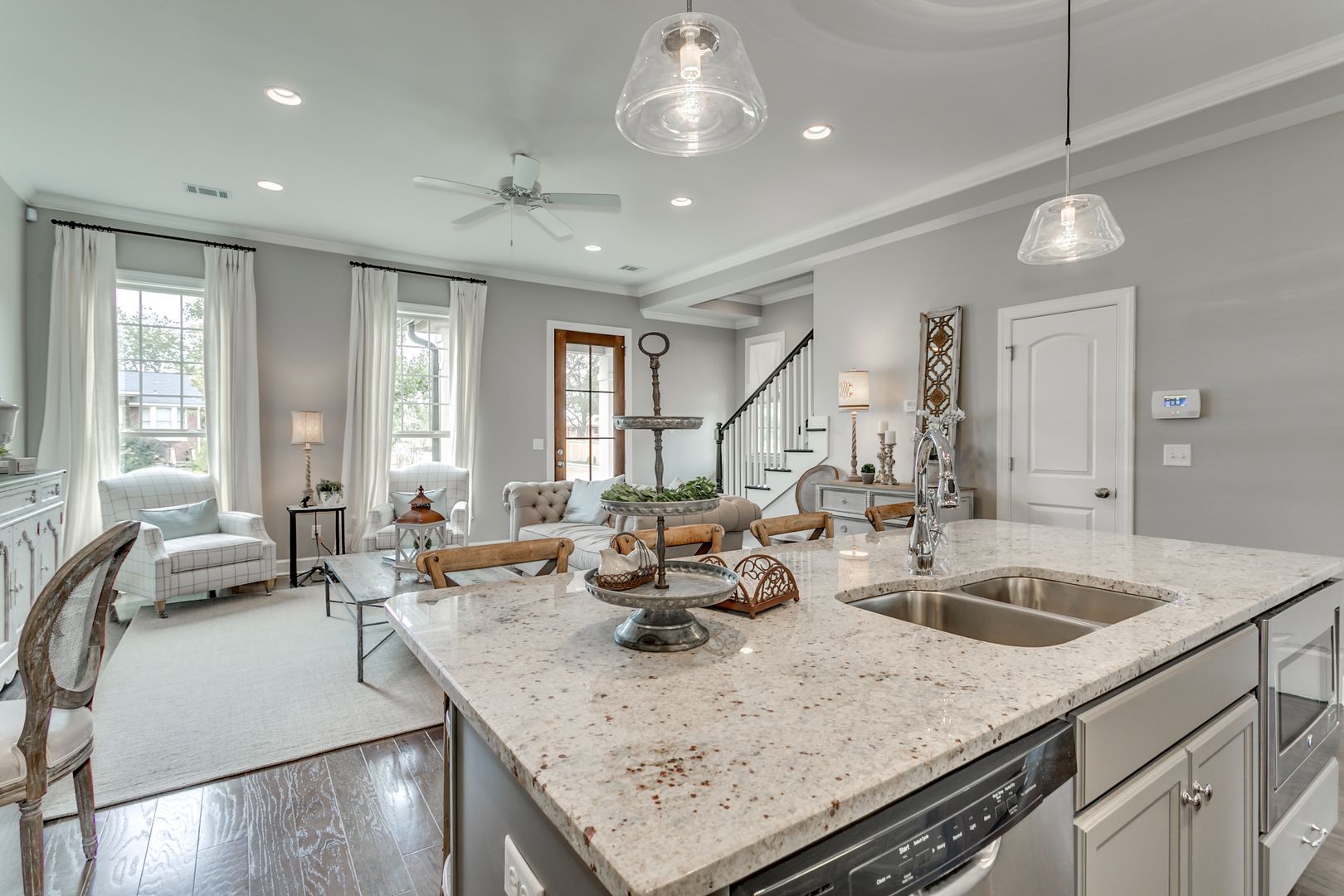 Open-concept kitchen and living area with a large island and granite countertop.