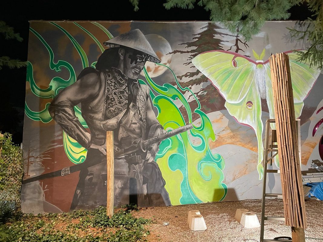 A mural featuring a figure in a conical hat beside a large, bright green moth, set against a dark, nocturnal backdrop.