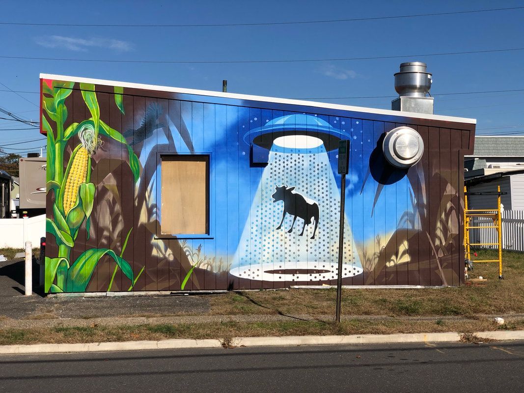 A statue of a mosaic head is sitting on a wooden stump.
