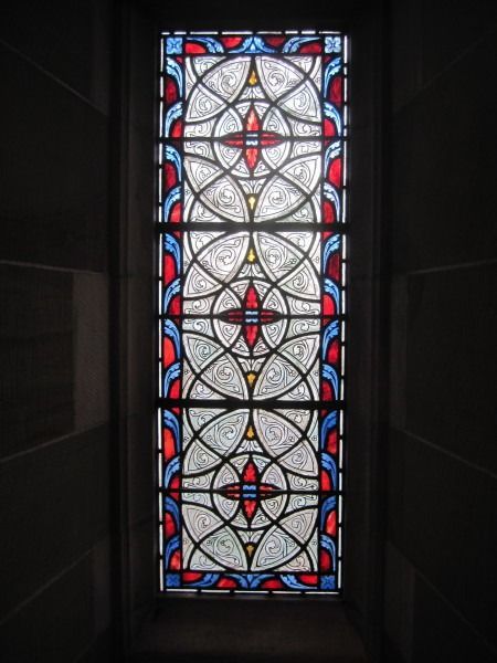 A person wearing a cow-print suit stands against a mural of a UFO beaming a cow up from a cornfield.