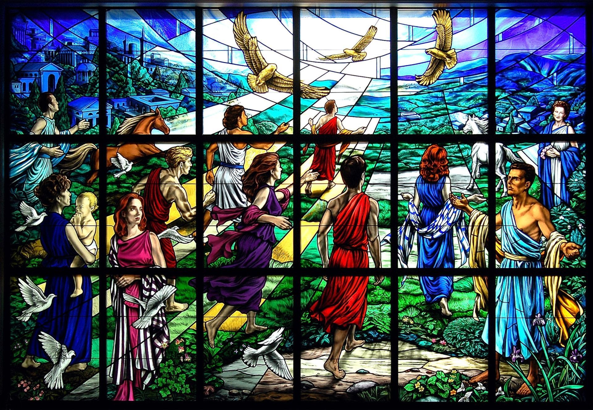 Stained-glass window depicting people in classical robes walking through a lush landscape towards a glowing path.