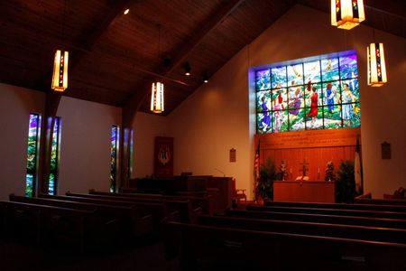 A mural on a building side depicts a UFO beaming up a cow, set against a background of a cornfield.