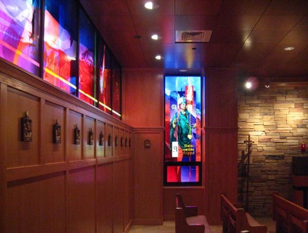 A person in a cow-print suit stands before a mural of a UFO abducting a cow in a cornfield.