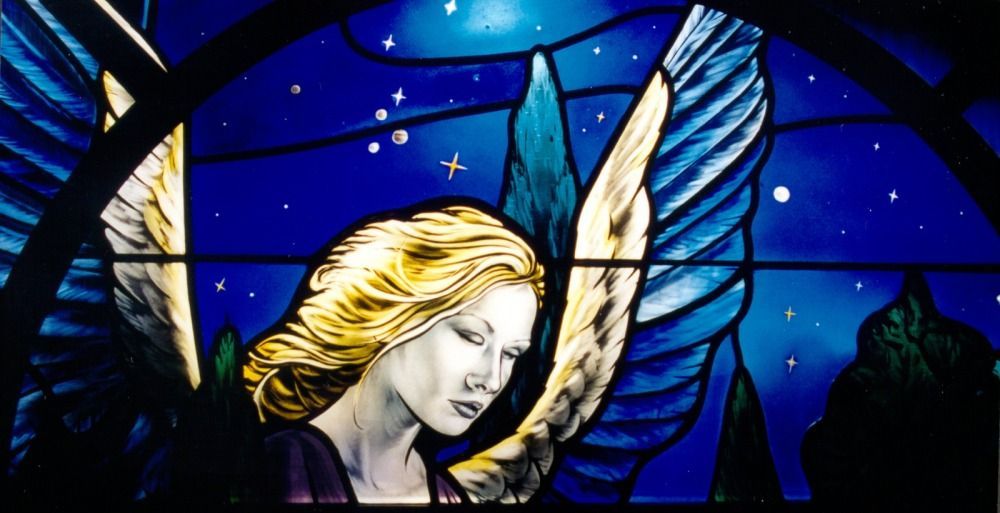 Stained glass artwork of a winged figure with blonde hair, set against a dark blue starry night sky.