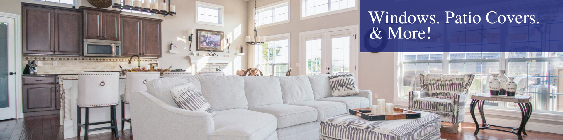 Luxury living room with white sofa, kitchen backdrop, and patio doors to a bright outdoor view