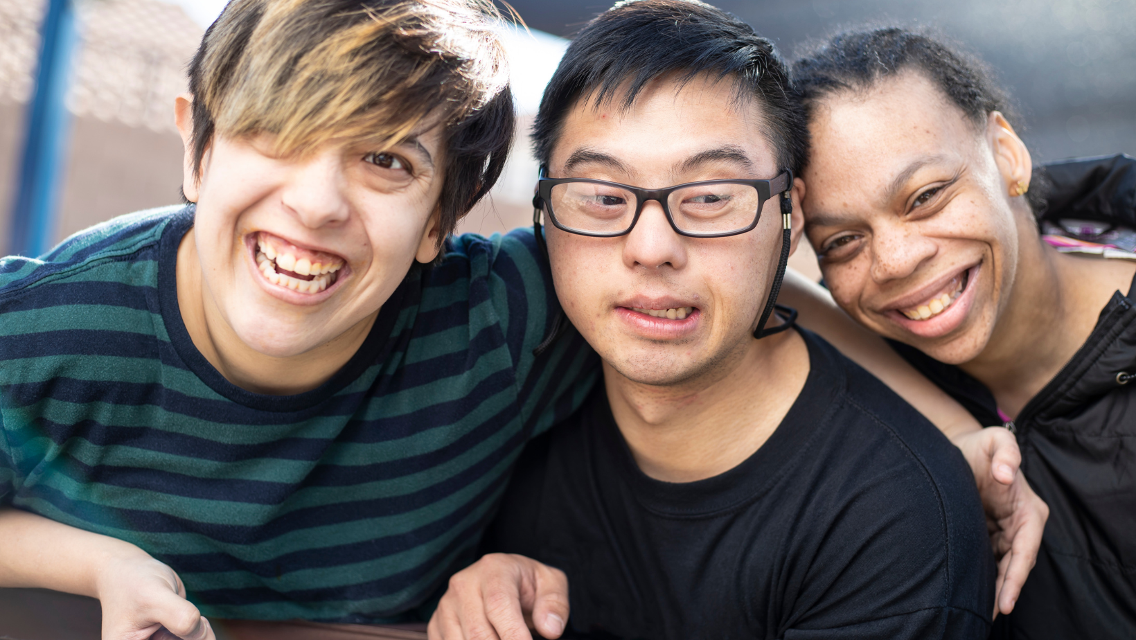 three young people are posing for a picture together and smiling .