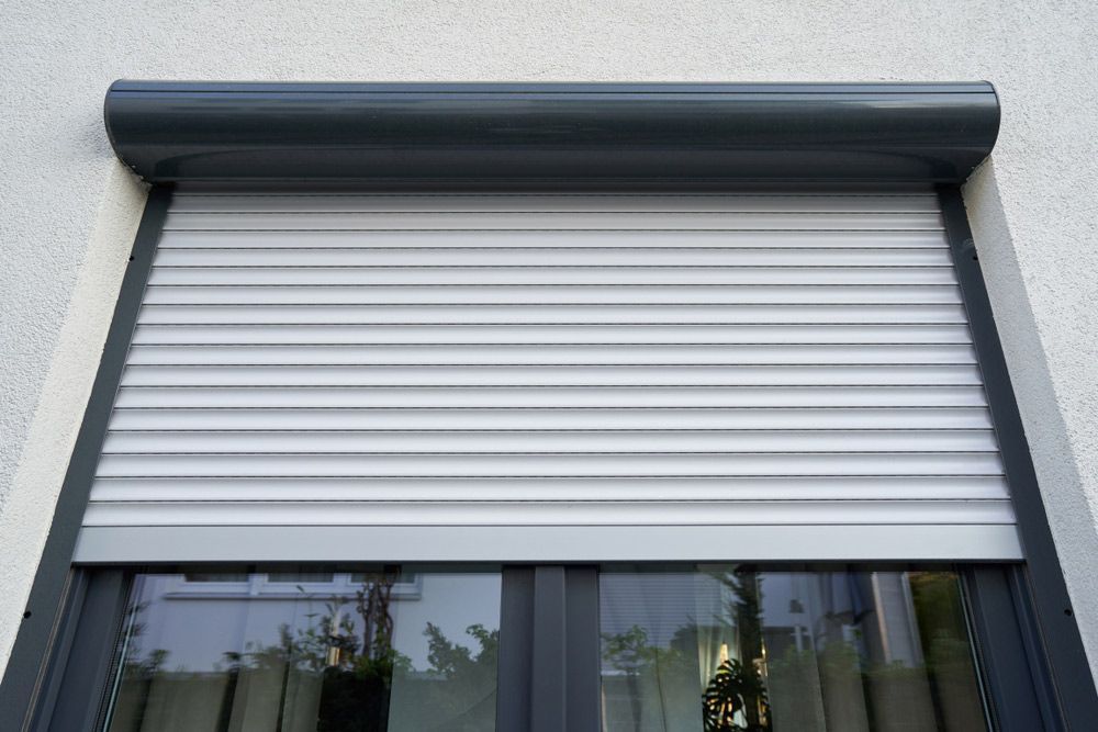 Light Roller Shutter Curtains Mounted on A Dark Window — Blinds in Bogangar, NSW