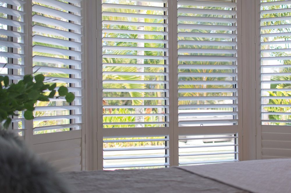 A White Plantation Shutters In Bedroom — Blinds in Bogangar, NSW