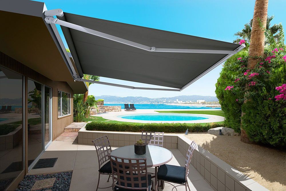 Black Folding Arm Awning Enhances Patio Area — Blinds in Bogangar, NSW