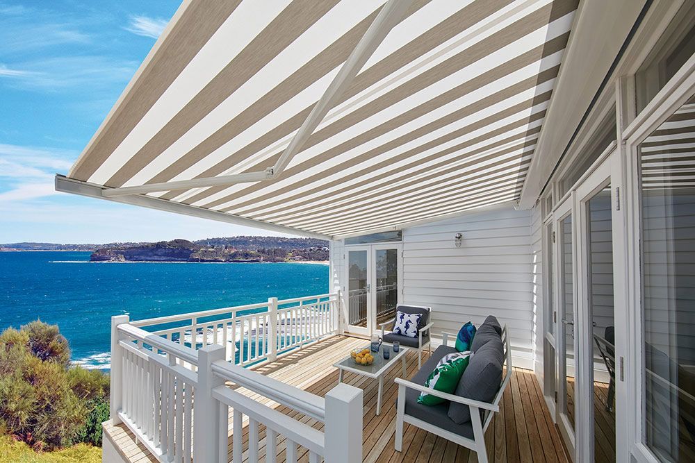 Folding Arm Awning Stripped Patio Area with People Around — Blinds in Bogangar, NSW