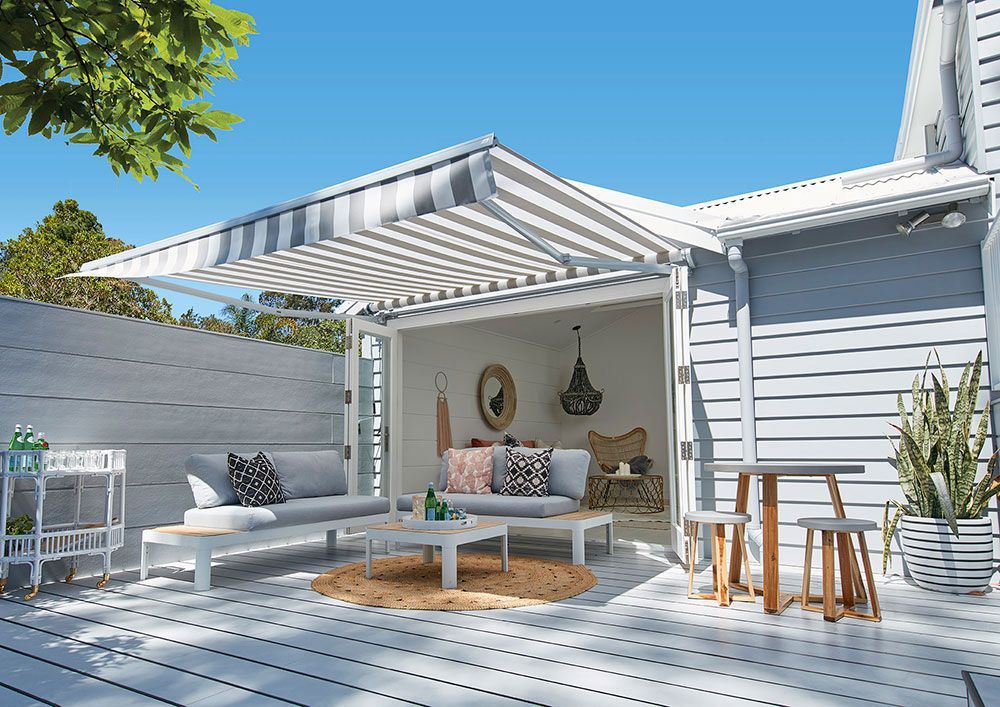 Folding Arm Striped Awning Enhancing Patio Appeal — Blinds in Bogangar, NSW
