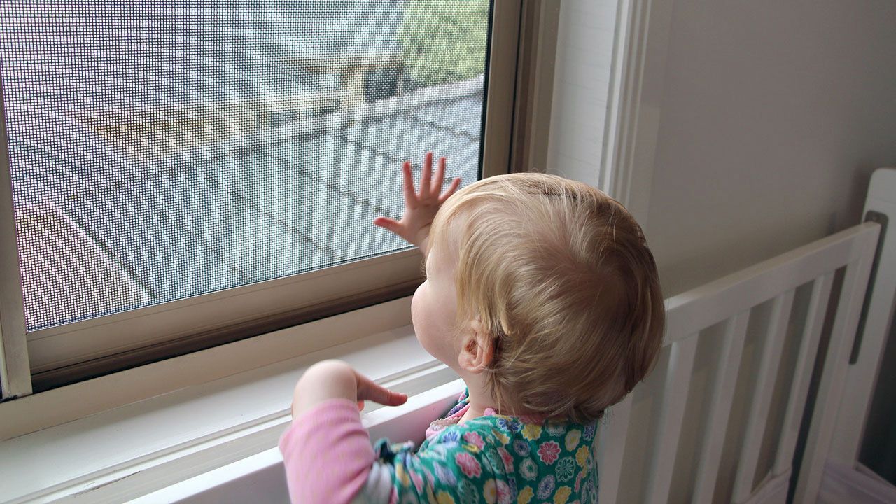 Child Looking Out A Window, Hand Touching The Screen
