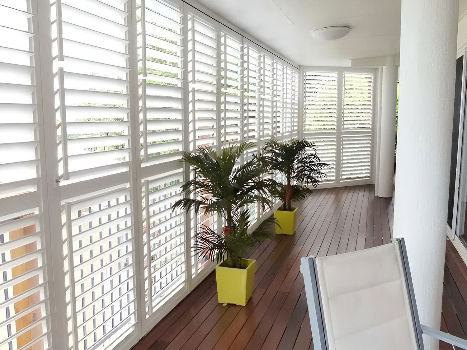 Patio with White Shutters, Potted Plants, and a Wooden Deck