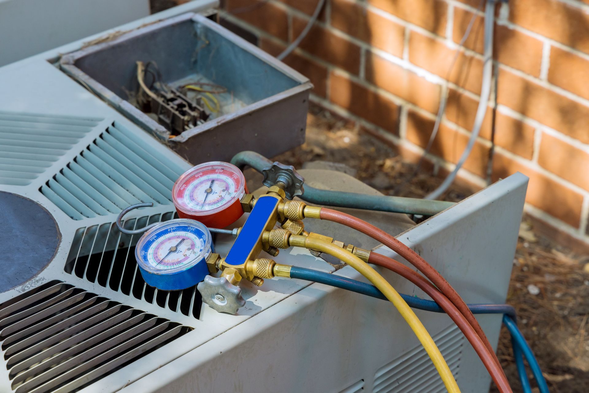 A close up of a air conditioner with gauges attached to it.