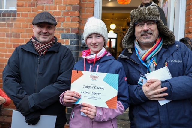 a girl holding a sign that reads Judge's Choice
